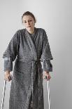 Woman Watching TV with Crutches-Anthony West-Photographic Print