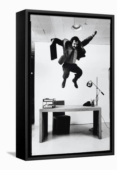 Architect and Designer Frank Gehry Jumping on a Desk in His Line of Cardboard Furniture-Ralph Morse-Framed Premier Image Canvas