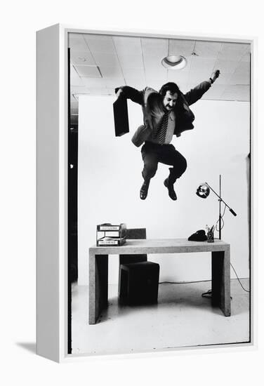 Architect and Designer Frank Gehry Jumping on a Desk in His Line of Cardboard Furniture-Ralph Morse-Framed Premier Image Canvas