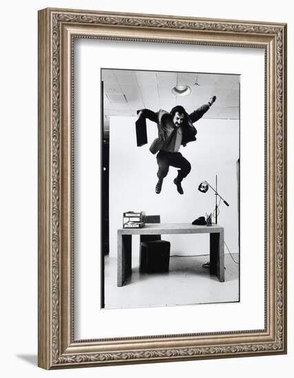 Architect and Designer Frank Gehry Jumping on a Desk in His Line of Cardboard Furniture-Ralph Morse-Framed Photographic Print