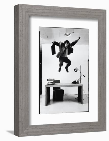 Architect and Designer Frank Gehry Jumping on a Desk in His Line of Cardboard Furniture-Ralph Morse-Framed Photographic Print