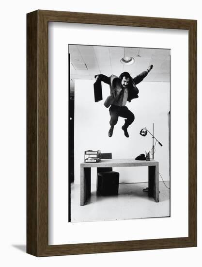 Architect and Designer Frank Gehry Jumping on a Desk in His Line of Cardboard Furniture-Ralph Morse-Framed Photographic Print