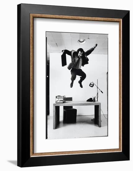 Architect and Designer Frank Gehry Jumping on a Desk in His Line of Cardboard Furniture-Ralph Morse-Framed Photographic Print