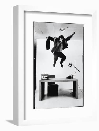 Architect and Designer Frank Gehry Jumping on a Desk in His Line of Cardboard Furniture-Ralph Morse-Framed Photographic Print