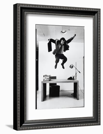 Architect and Designer Frank Gehry Jumping on a Desk in His Line of Cardboard Furniture-Ralph Morse-Framed Photographic Print