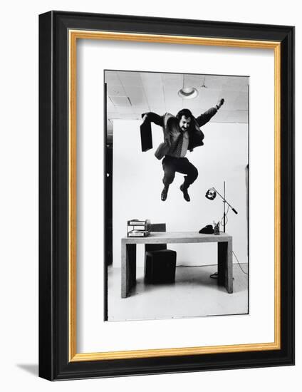 Architect and Designer Frank Gehry Jumping on a Desk in His Line of Cardboard Furniture-Ralph Morse-Framed Photographic Print