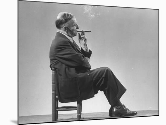 Architect Frederick Kiesler Seated in a Child's Chair, Smoking a Cigar, at Gjon Mili's Studio-Gjon Mili-Mounted Premium Photographic Print