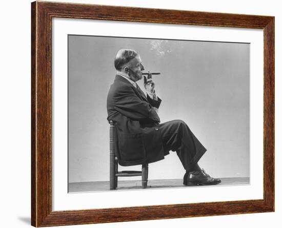 Architect Frederick Kiesler Seated in a Child's Chair, Smoking a Cigar, at Gjon Mili's Studio-Gjon Mili-Framed Premium Photographic Print