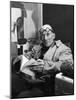 Architect Le Corbusier Sitting in Chair and Holding Book in Hands-Nina Leen-Mounted Premium Photographic Print