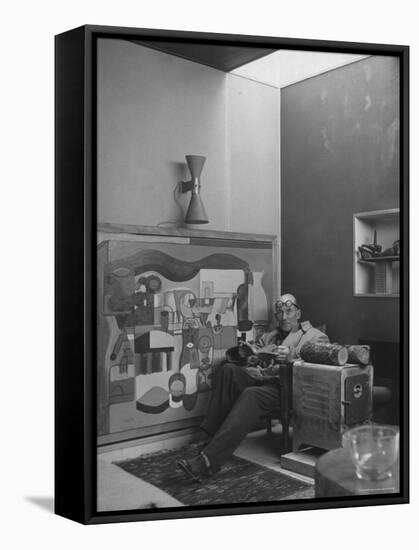 Architect Le Corbusier Sitting in Chair with Book in Hands, Glasses Perched on His Forehead-Nina Leen-Framed Premier Image Canvas