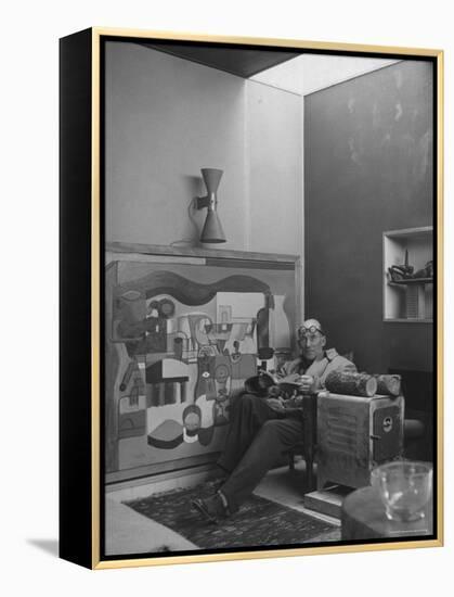 Architect Le Corbusier Sitting in Chair with Book in Hands, Glasses Perched on His Forehead-Nina Leen-Framed Premier Image Canvas