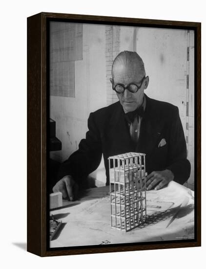 Architect Le Corbusier Studying Architectural Plans and Small Model of Building in His Office-Nina Leen-Framed Premier Image Canvas