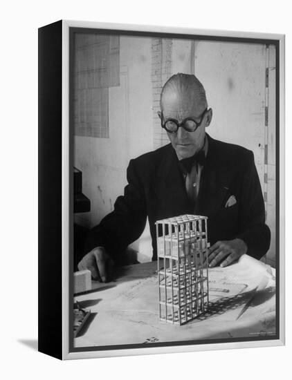 Architect Le Corbusier Studying Architectural Plans and Small Model of Building in His Office-Nina Leen-Framed Premier Image Canvas