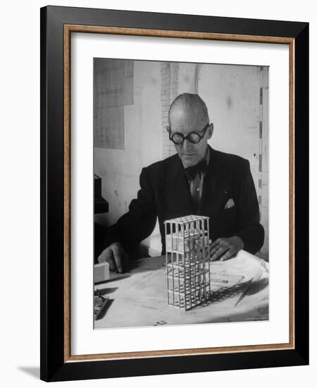 Architect Le Corbusier Studying Architectural Plans and Small Model of Building in His Office-Nina Leen-Framed Premium Photographic Print