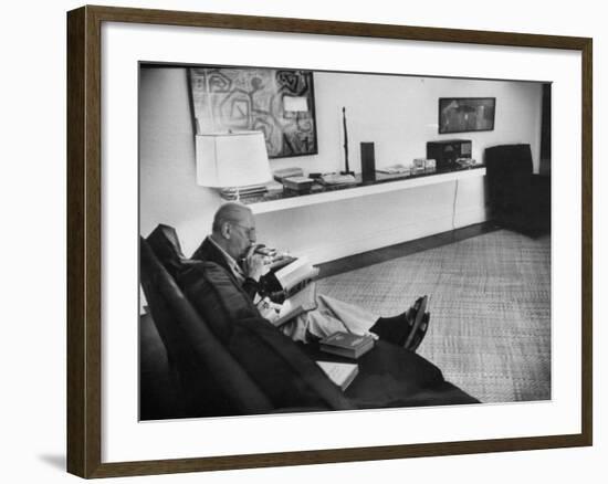 Architect Mies Van Der Rohe Relaxing on Couch While Smoking Cigar and Reading at Home-null-Framed Premium Photographic Print