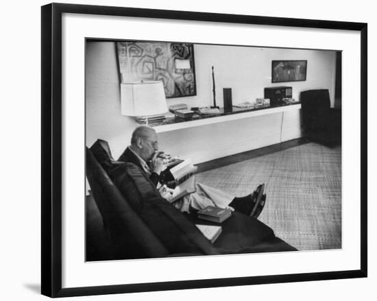 Architect Mies Van Der Rohe Relaxing on Couch While Smoking Cigar and Reading at Home-null-Framed Premium Photographic Print