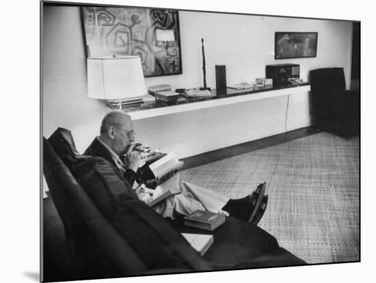 Architect Mies Van Der Rohe Relaxing on Couch While Smoking Cigar and Reading at Home-null-Mounted Premium Photographic Print