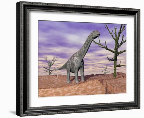 Argentinosaurus Standing on the Cracked Desert Ground Next to Dead Trees-null-Framed Art Print