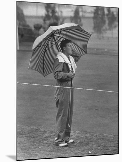 Australian Golfer Peter Thompson, Standing under Oversized Umbrella During the Los Angeles Open-Allan Grant-Mounted Premium Photographic Print