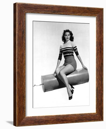 Ava Gardner seated on Giant firecracker, c. 1945 (b/w photo)-null-Framed Photo