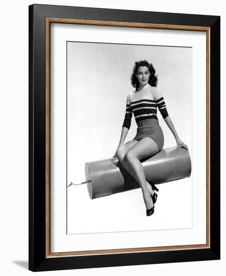 Ava Gardner seated on Giant firecracker, c. 1945 (b/w photo)-null-Framed Photo