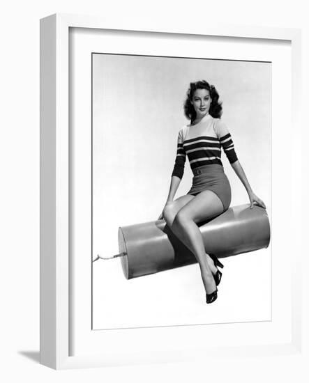 Ava Gardner seated on Giant firecracker, c. 1945 (b/w photo)-null-Framed Photo