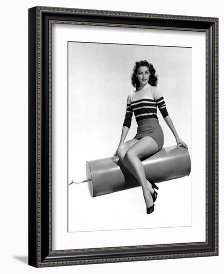 Ava Gardner seated on Giant firecracker, c. 1945 (b/w photo)-null-Framed Photo