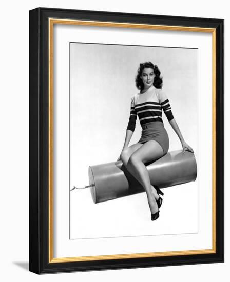 Ava Gardner seated on Giant firecracker, c. 1945 (b/w photo)-null-Framed Photo