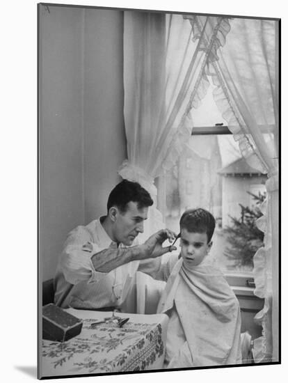 B.F. Goodrich Engineer Frank Herzegh Developed the Tubeless Tire, Cutting his son Frankie's hair-Alfred Eisenstaedt-Mounted Photographic Print