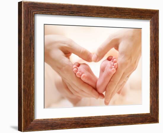 Baby Feet in Mother Hands. Tiny Newborn Baby's Feet on Female Heart Shaped Hands Closeup. Mom and H-Subbotina Anna-Framed Photographic Print