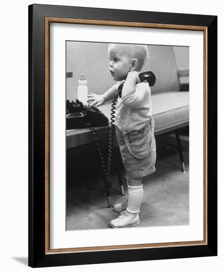 Baby Playing with a Telephone-Yale Joel-Framed Photographic Print