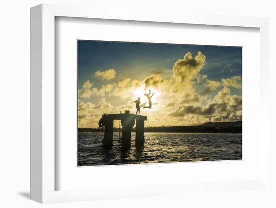 Backlit local boys jumping into the water of the lagoon of Wallis from a platform, Wallis and Futun-Michael Runkel-Framed Photographic Print