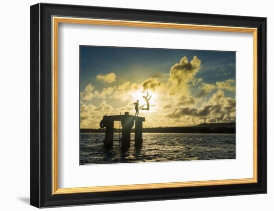 Backlit local boys jumping into the water of the lagoon of Wallis from a platform, Wallis and Futun-Michael Runkel-Framed Photographic Print