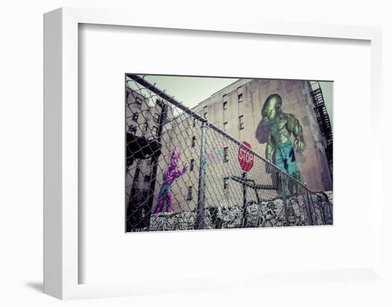 Backyard scene Graffiti of a pink and green superpower baby, Little Italy, Manhattan, New York, USA-Andrea Lang-Framed Photographic Print