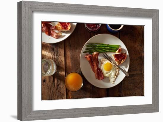 Bacon, A Sunny Side Up Egg, Pan Grilled Asparagus And Toast With Raspberry Jam On Wooden Farmtable-Shea Evans-Framed Photographic Print