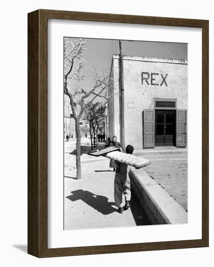 Baker's Apprentice Carrying a Large Tray of Bread Dough-Alfred Eisenstaedt-Framed Photographic Print