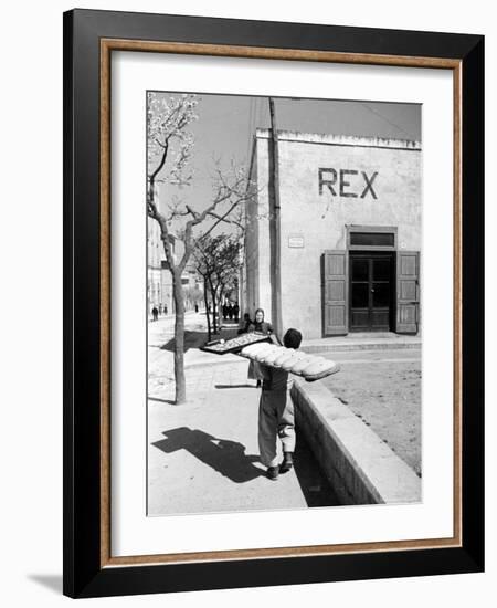 Baker's Apprentice Carrying a Large Tray of Bread Dough-Alfred Eisenstaedt-Framed Photographic Print