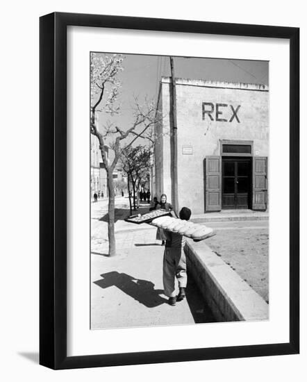 Baker's Apprentice Carrying a Large Tray of Bread Dough-Alfred Eisenstaedt-Framed Photographic Print