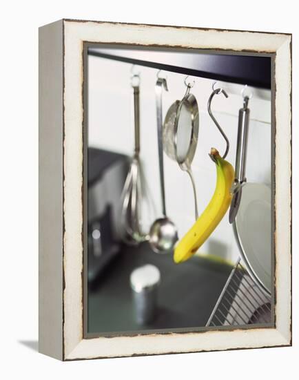 Banana and Kitchen Tools Hanging on Hooks in Kitchen-Kröger & Gross-Framed Premier Image Canvas