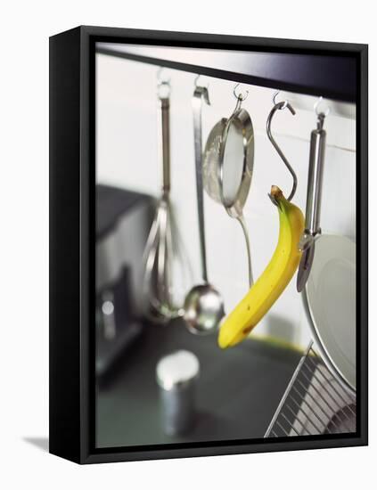 Banana and Kitchen Tools Hanging on Hooks in Kitchen-Kröger & Gross-Framed Premier Image Canvas