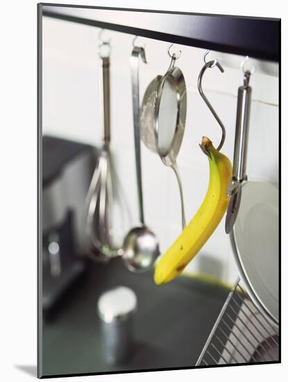 Banana and Kitchen Tools Hanging on Hooks in Kitchen-Kröger & Gross-Mounted Photographic Print