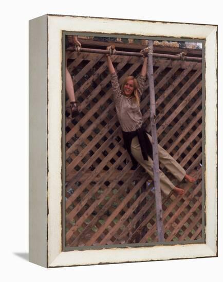 Barefoot Girl Swinging on Structure Containing Baby Chicks in Coop, Woodstock Music and Art Fair-John Dominis-Framed Premier Image Canvas