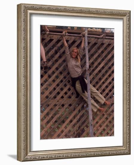 Barefoot Girl Swinging on Structure Containing Baby Chicks in Coop, Woodstock Music and Art Fair-John Dominis-Framed Photographic Print