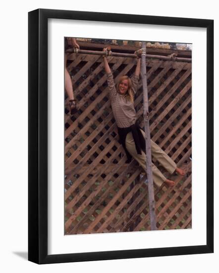 Barefoot Girl Swinging on Structure Containing Baby Chicks in Coop, Woodstock Music and Art Fair-John Dominis-Framed Photographic Print