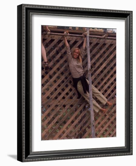 Barefoot Girl Swinging on Structure Containing Baby Chicks in Coop, Woodstock Music and Art Fair-John Dominis-Framed Photographic Print