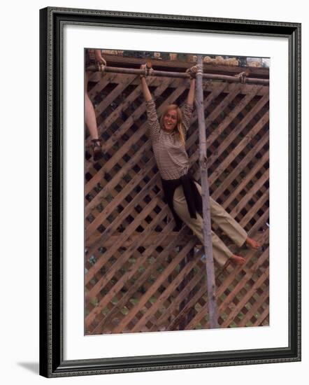 Barefoot Girl Swinging on Structure Containing Baby Chicks in Coop, Woodstock Music and Art Fair-John Dominis-Framed Photographic Print