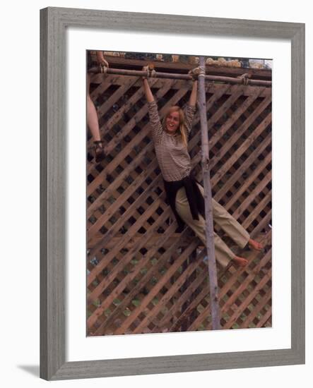 Barefoot Girl Swinging on Structure Containing Baby Chicks in Coop, Woodstock Music and Art Fair-John Dominis-Framed Photographic Print