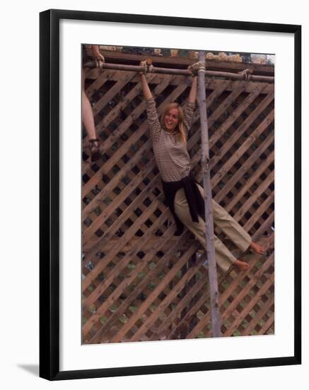 Barefoot Girl Swinging on Structure Containing Baby Chicks in Coop, Woodstock Music and Art Fair-John Dominis-Framed Photographic Print