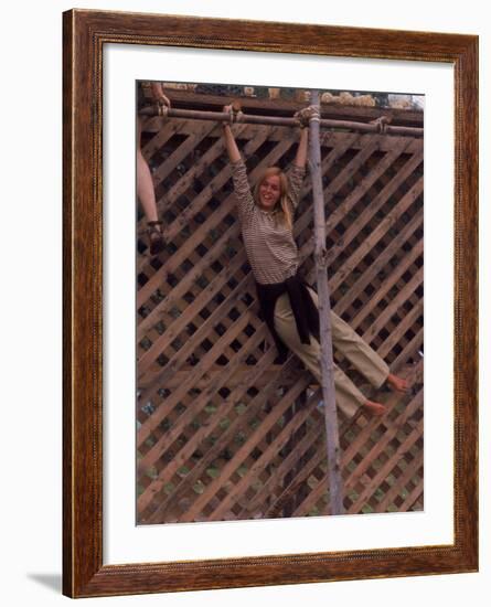 Barefoot Girl Swinging on Structure Containing Baby Chicks in Coop, Woodstock Music and Art Fair-John Dominis-Framed Photographic Print