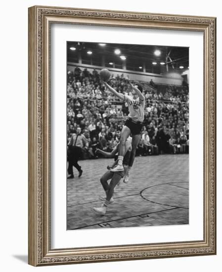 Basketball Player Tom Gola Leaping in the Air to Make a Shot During a Basketball Game-null-Framed Photographic Print